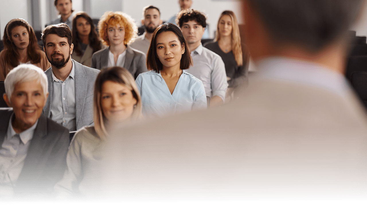 Group of business people attending a seminar in board room. Focus is on Chinese woman and man next to her.