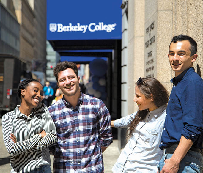 Four Berkeley College New York City students smiling and standing together outside with the Berkeley College sign in the background.